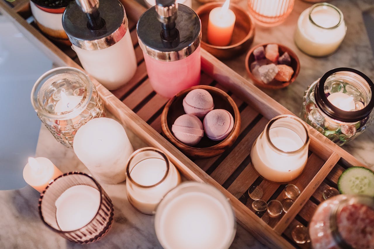 A cozy spa scene featuring candles, lotion, and essential oils for a relaxing atmosphere.